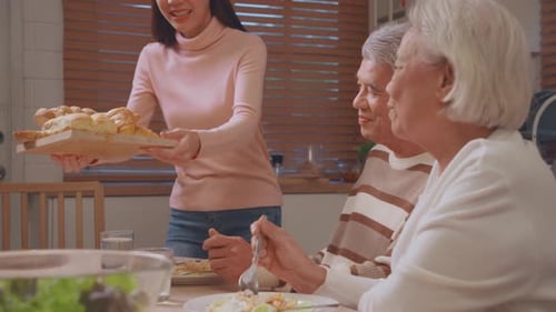 Family Meal with Senior Couple and Young Woman