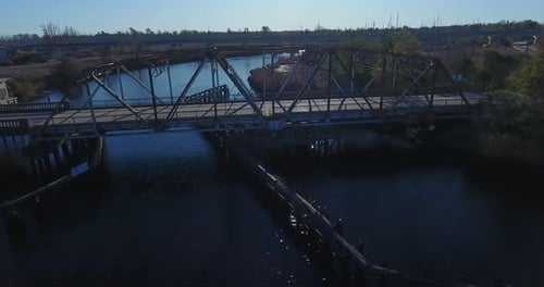 Die Drohne fliegt an einer alten Brücke vorbei, über einen Fluss.