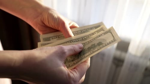 Counting one hundred dollar bills by a woman engaged in cash transactions