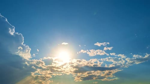 Sunlight Shines Through Clouds in a Blue Sky