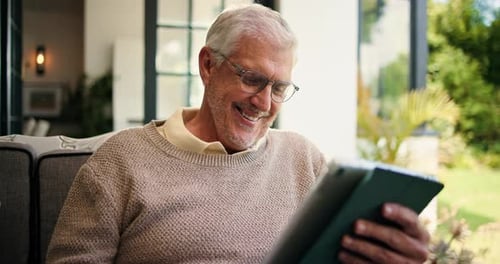Senior Man Smiling while Using Tablet Device Outside