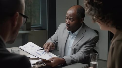 Business People Reviewing Charts in Modern Office