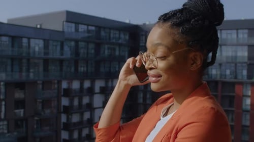 Smiling Woman on Phone with City Backdrop