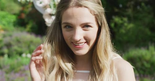 Smiling Blonde Woman in Lush Green Garden