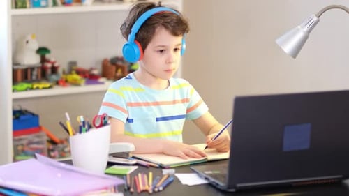 Focused Boy Studies at Desk with Laptop
