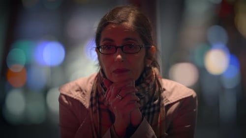 Woman Standing on City Street at Night