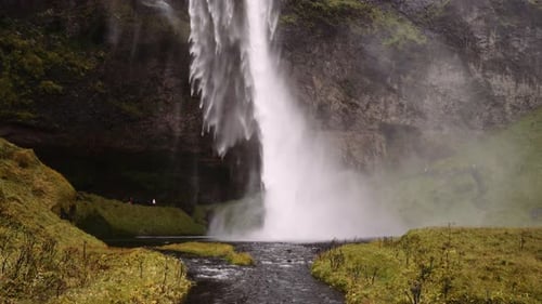 Majestic Waterfall Flowing Into Stream