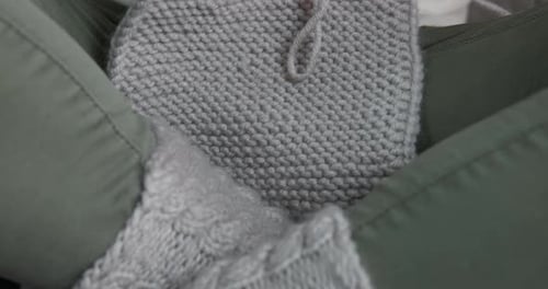 Hands Knitting a Gray Wool Piece