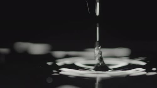 Water Drops Hit Liquid Surface Causing Ripples and Small Splash