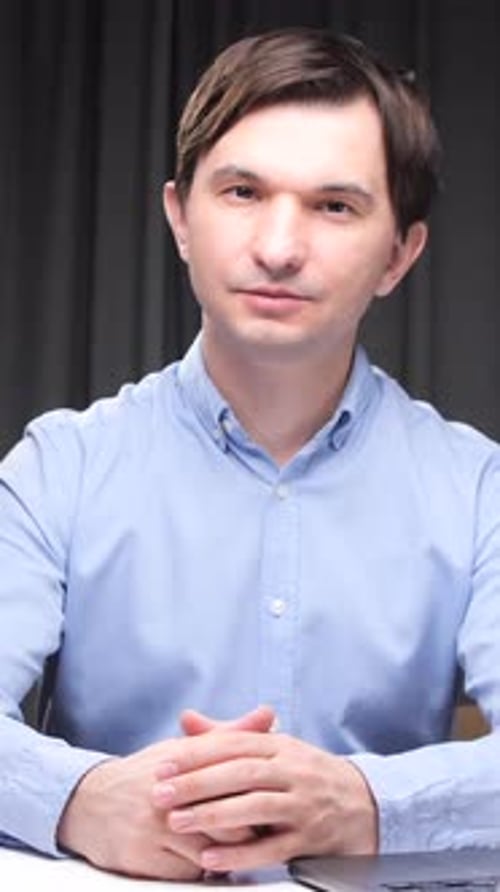 Vertical Video Office Worker Sitting at Desk with Folders and Laptop