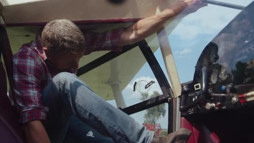 Aircraft engineer prepares ultralight plane for flight in sunny cockpit cabin