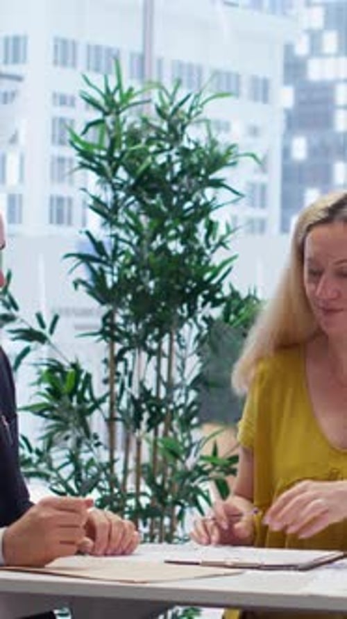 Woman Signs Contract During Business Meeting
