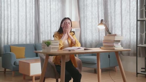 Tired Student Studying at Desk in Cozy Home