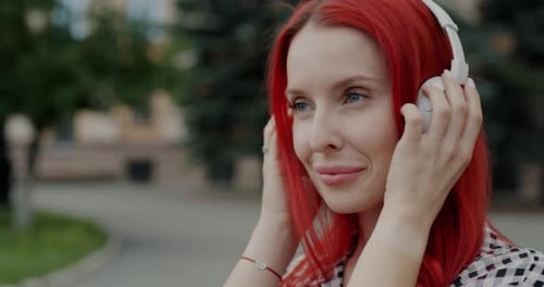 Portrait of Happy Girl Dancing Listening to Music Through Headphones Having Fun in City Street