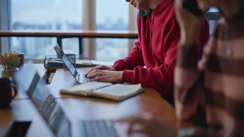 Call Center Workers Talking Cellphones Looking Laptops at Workplace Closeup
