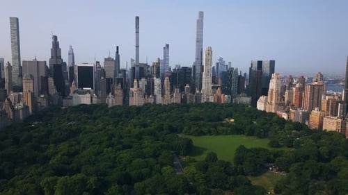 Panoramic drone shot over Central park with Manhattan Midtown highrise background