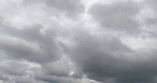 Rarely appearing blue sky from behind the grey clouds. Overcast horizon from low angle view.