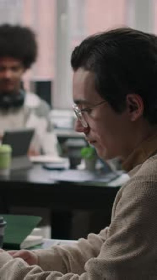 Vertical of Young Male Programmer Coding in Office