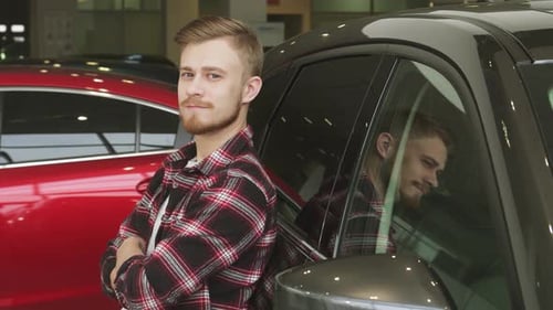 Confident Man Giving a Thumbs Up While Leaning on a Sleek New Car at the Dealership