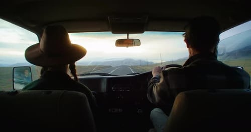 Couple Driving a Van on a Road Trip at Sunset Enjoying the Landscape