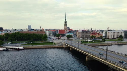 Aerial footage of Daugava River and a bridge over it with lots of traffic, Riga, 4k
