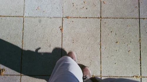 First Person Walking on Stone Pavement with Shadow