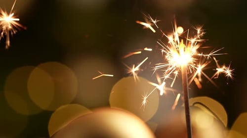 Sparkler Burning Brightly with Golden Christmas Ornaments
