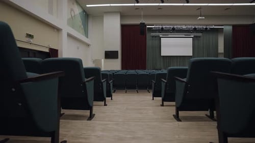 Projector Mounted on Wall of Stage in Spacious Auditorium