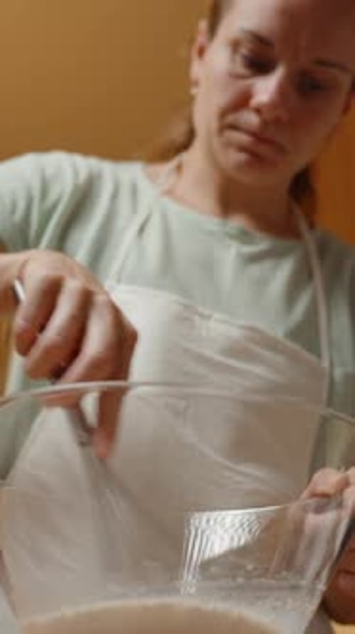 Vertical video. Whisking Ingredients in a Large Glass Bowl, Preparing Batter for a Baking Recipe in