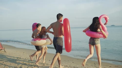 Slow motion: Close up group friends running enjoy life playing and freedom beach at sunset