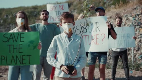 Young Boy Holding Potted Tree at Climate Change Rally