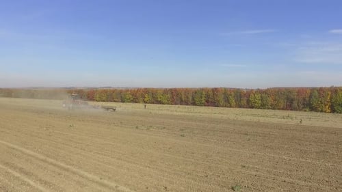 Big red combine working on the field cultivating and applying nitrogen ASP