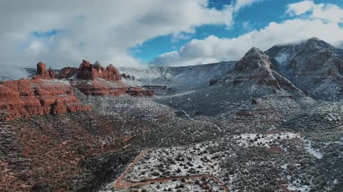 Panorama Of Red Sandstone Rock Formations Covered In Snow During Winter. - aerial descend