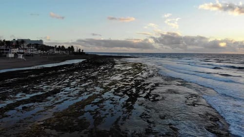 Beautiful sunset casting golden hues over rocky coast of Tenerife