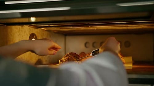 baker measures the temperature of freshly baked bread in the oven with a thermometer bakery