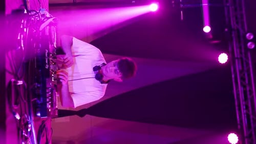DJ using turntable performing in an electronic concert in nightclub