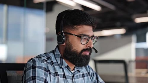Businessman in Headset Providing Customer Support in Modern Office