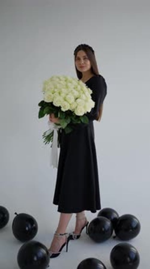 Elegant Woman Holding Roses Among Balloons