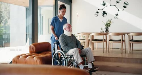 Female Nurse Pushing Senior Man in Wheelchair Indoors