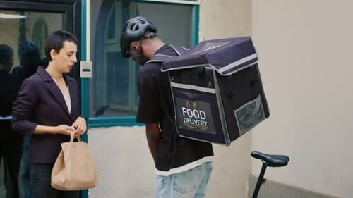 Delivery Service Worker Giving Fastfood in Paperbag to Woman