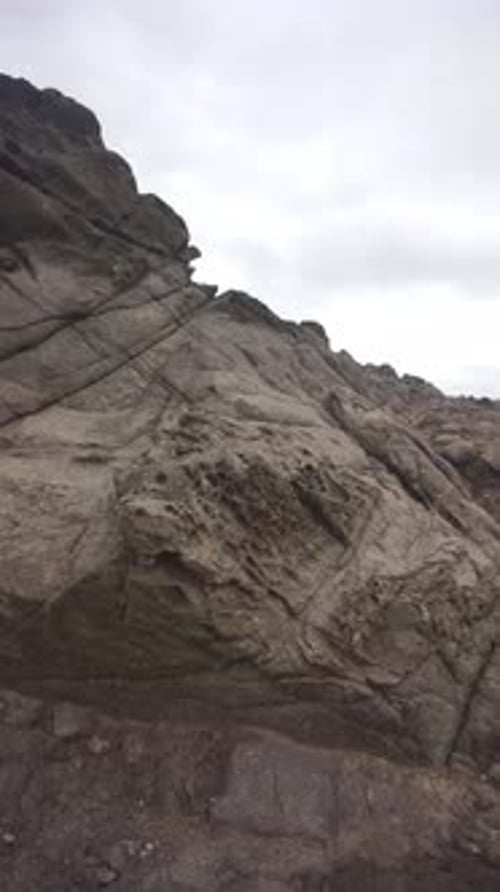 sea water accompanied by crashing waves and coral rocks with cloudy skies in the afternoon