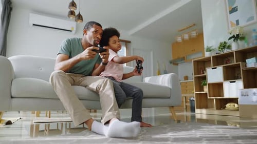 Father and Child Playing Video Games at Home