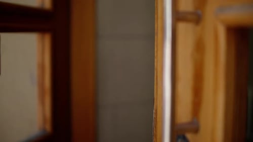Woman Opens Wooden Doorway and Enters Inside