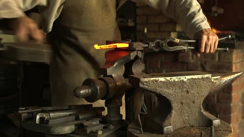 Blacksmith Shaping Heated Metal on Anvil With Hammer