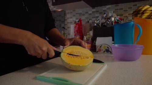 Person, die eine Melone halbiert