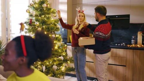 Close Up Young Multiracial Friends Enjoying Decorating Christmas Tree Exchange Gifts Holidays