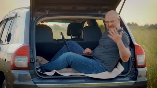 Homem falando remotamente emocionalmente por meio de um bate-papo de vídeo corporativo acenando com as mãos trabalhando no laptop