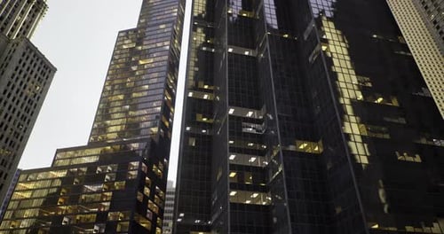 Edificios urbanos modernos iluminados al anochecer en una ciudad bulliciosa