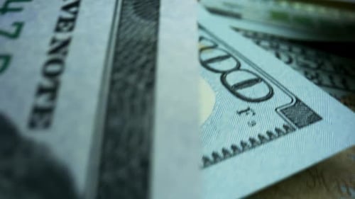 Macro of US Currency Moving Across Surface