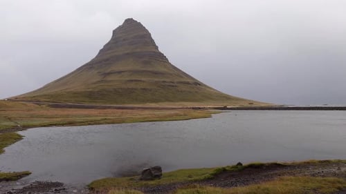 Famous Kirkjufell mountain on a rainy day at the Kirkjufellsfoss waterfall. Snæfellsnes Peninsula, I